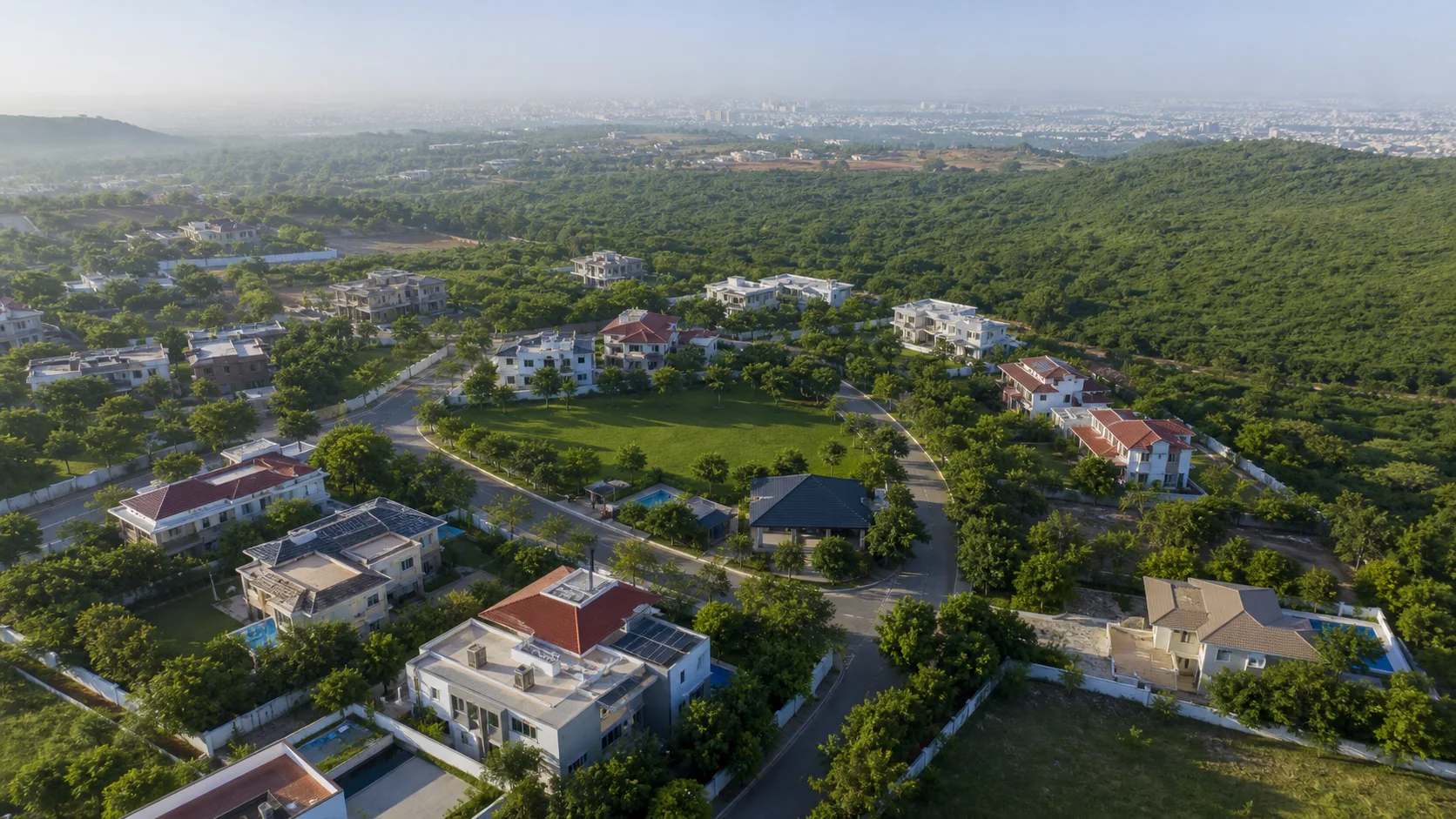 Low-density villa community beside a green forest edge